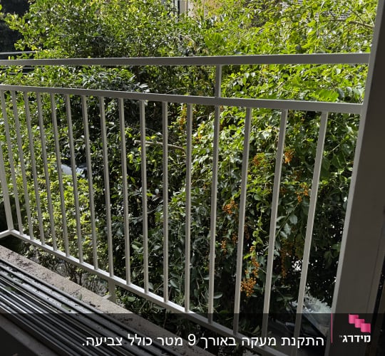 מעקה מתכת לבן עם מסגרת חלון בצד